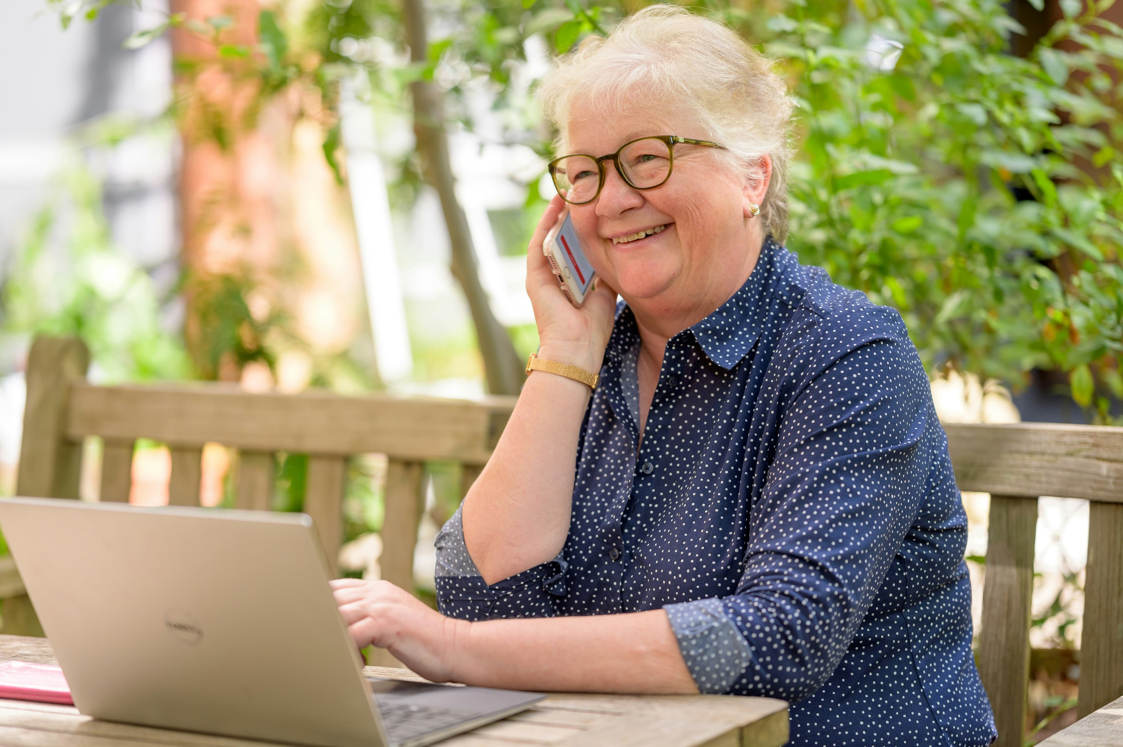 Resident using a tablet with caregiver support in a bright common area